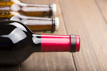 Close-up of a bottle of wine and two bottles of beer on the wooden background. Copy space. Horizontal shoot. の写真素材