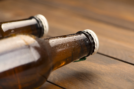 Close-up of two bottles of beer on the wooden background. Copy space.の写真素材
