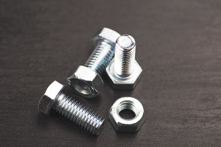 Nuts and bolts on black background.