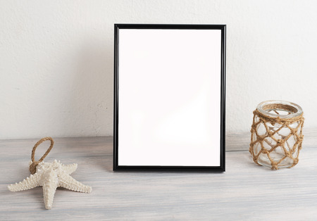 Picture frame next to decorative objects on wooden table. Decor.