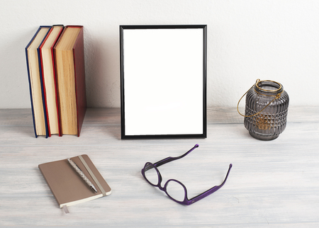 Photo frame on wooden table next to books. Decor.の写真素材