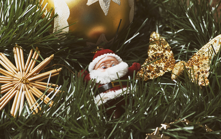 Christmas decoration with ball and golden butterfly next to santa claus on Christmas tree.の写真素材