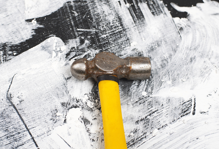 Hammer next to nails on wooden base.の写真素材
