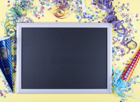 Celebratory yellow background with confetti and balloons, with a blackboard in the middle. Copyspace Mockup.の写真素材