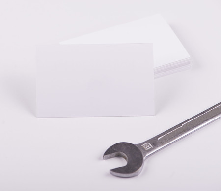 Business cards next to tool on white background. Isolated. Mockup.の写真素材
