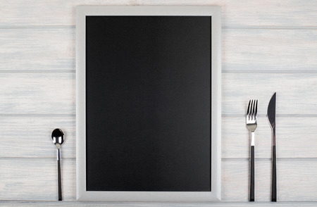 Blackboard between covered kitchen on wooden table. Menu. Foodの写真素材