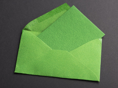 Letter green with a card inside on black background. Mockup.の写真素材
