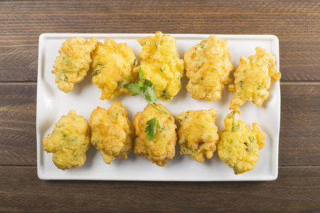 Cod fritters on brown wooden table. Spanish food.の写真素材