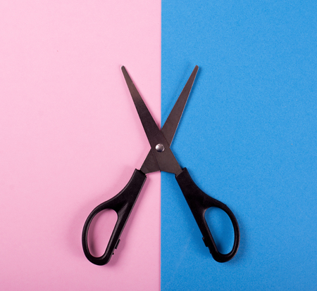Scissors on pink and blue background. Isolated.の写真素材