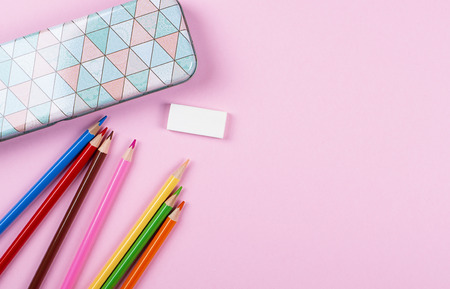 Colored pencils and stationery on pink background. Back to school concept. Copy space.