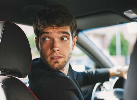 Attractive young man with a beard drives reverse.の写真素材