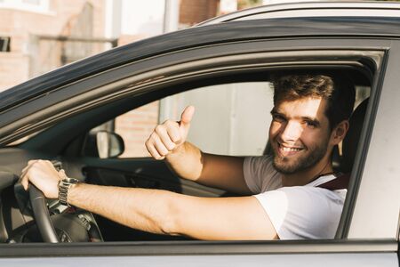 Attractive young man with beard wearing shirt smiles and says ok looking at the camera.の写真素材