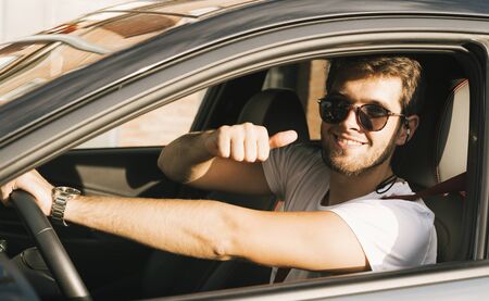 Attractive young man with beard and sunglasses says ok to camera with his hand.Sunの写真素材