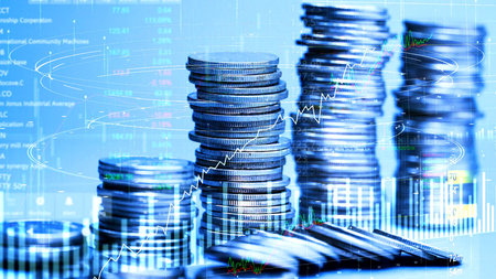 Stacks of coins with financial graph and chart on blue background.の写真素材