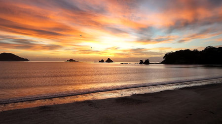 Behold the Stunning Sunset Casting its Beauty over the Tranquil Beach and Relaxing Wavesの写真素材