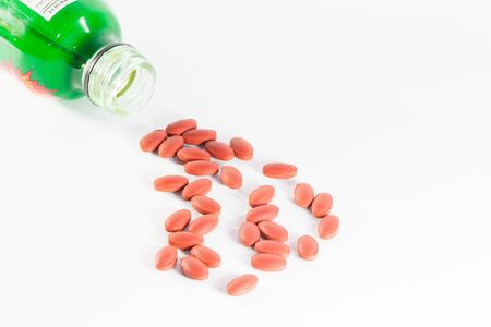 Pills of ferrous fumarate 200 mg with vitamins for blood donor spilling out of bottleの写真素材
