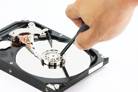 hard disk with hand put hammer at the top on white backgound