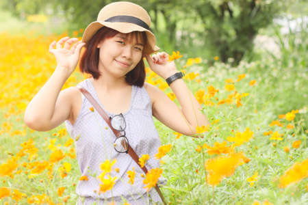 Smiling women in a garden many of flower as a background
