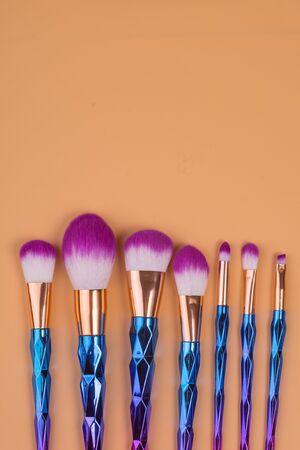make up brushes isolated on a yellow orange pastel backgroundの写真素材