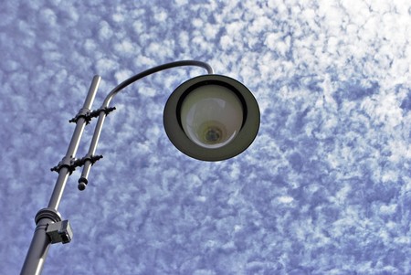 blue sky with white clouds background textures and lamppost in the foreground