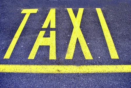 yellow taxi sign on asphaltの写真素材