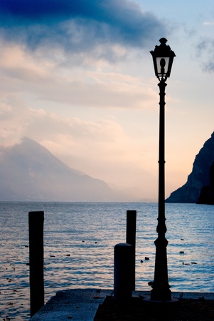 lamp for lighting the city with background on Garda Lakeの写真素材