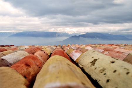 terra cotta tiled roof with background views of the mountainsの写真素材