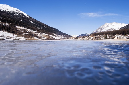 frozen lake in winter with the Alpine mountains and blue sky
