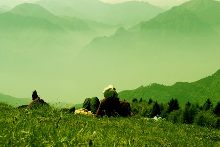 A hiker sitting on a cliff edge enjoying scenic viewの写真素材