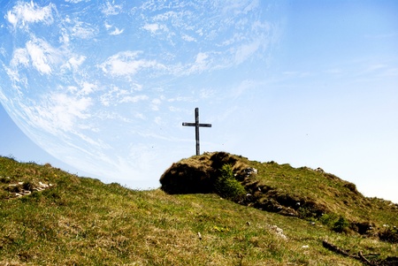 catholic cross in the mountains with planet Earthの写真素材