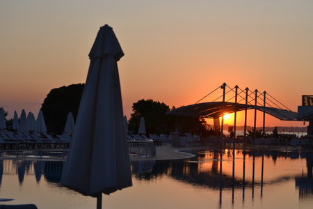 sunset with lots of umbrellas and poolの写真素材
