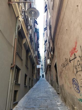 narrow alley for pedestrians with graffiti on wallsの写真素材