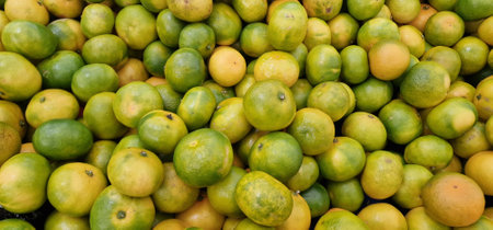 Tangerines displayed in a pile for sale in a vegetable market
