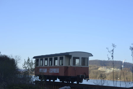 This horizontal photograph features a vintage red and cream railway carriage labeled Vulkan-Express...