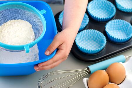 Boy or Girl Baking, sieving flour with clean hands and fingernailsの写真素材