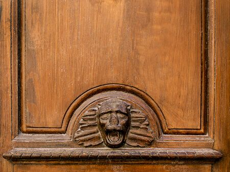 Old Spanish wooden door panel with carved face ideal for notice, copy space and room for textの写真素材