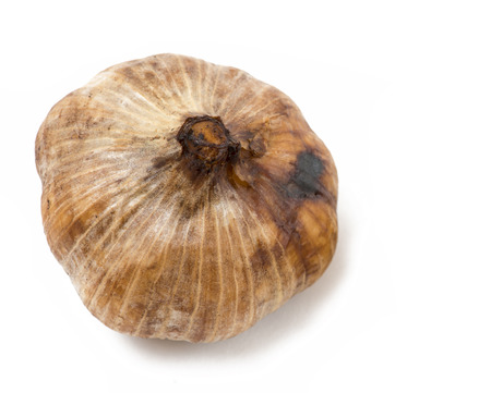 Detailed shot of a Whole bulb of home fermented Black Garlic. Latest wonder food ,rich in antioxidants, vitamins and minerals. On a isolated white backgroundの写真素材
