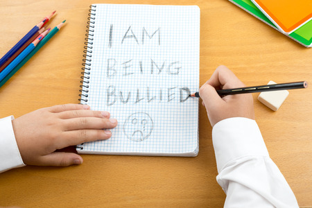 An image / poster covering the Social Issues of child abuse,  schoolchild in uniform at a desk...