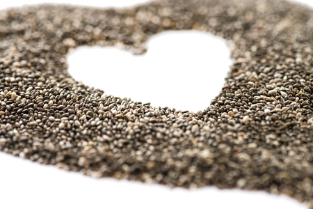 macro shot of chia seeds shaped into a heart shot on a white background with copy space very shallow depth of fieldの写真素材