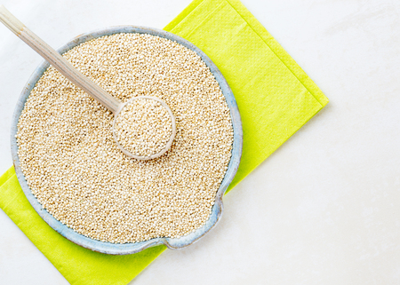 horizontal image of raw quinoa seed in a ceramic dish placed on a bright surface for the use of copy space or text の写真素材