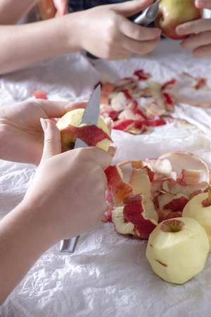 selective focus of a mum peeling apples with her daughter blurred background to ad copy spaceの写真素材