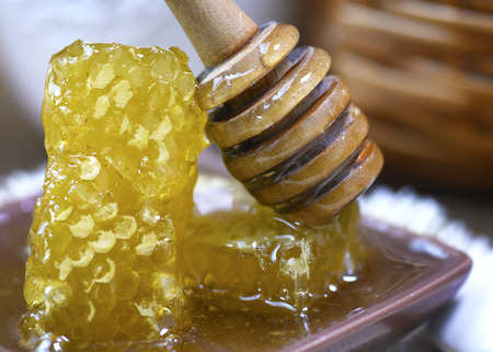 close up shot of honeycomb with a dipper covered in honey  focus on the subject to ad copyspace to the background の写真素材