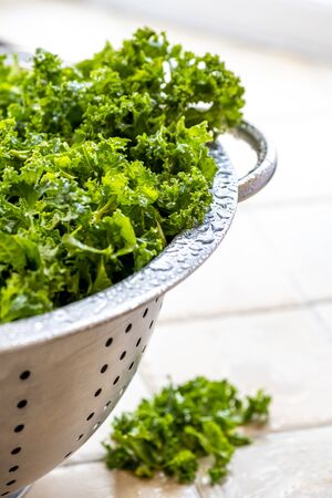 top view healthy organic kale  in a stainless steel colander,  selective focus shot for the use of copy space in the background showing other herbsの写真素材