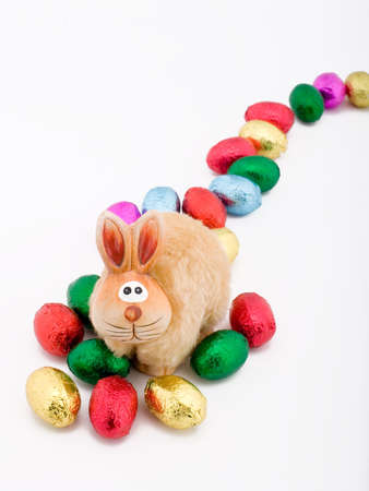 easter toy rabbit with some choclate eggsの写真素材