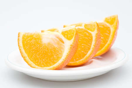 three sliced orange in the plate, isolated on whiteの写真素材