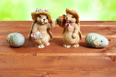 Two Easter bunny on wood background with decorative eggs