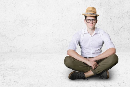 young boy with straw hat sitting on ground.の写真素材