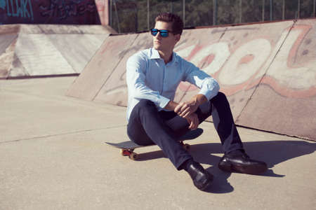 Yound caucasian business man relaxing on skateboardの写真素材