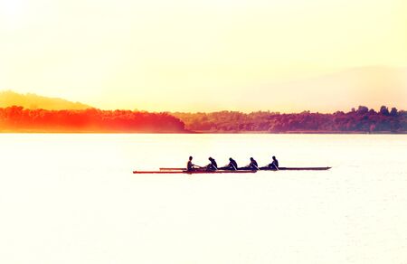 Silhouette of a man kayaking in the lake at sunset. Classical black and white photography of high...