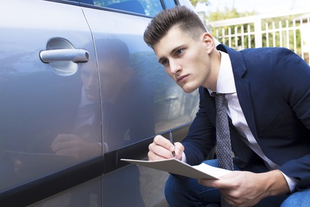 beautiful young insurance agent watching car damagedの写真素材